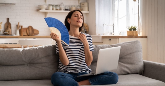 woman fanning herself in home