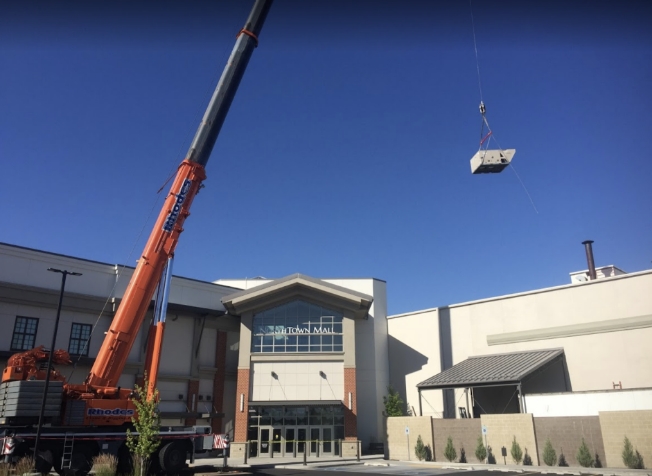 Crane lifting commercial HVAC unit